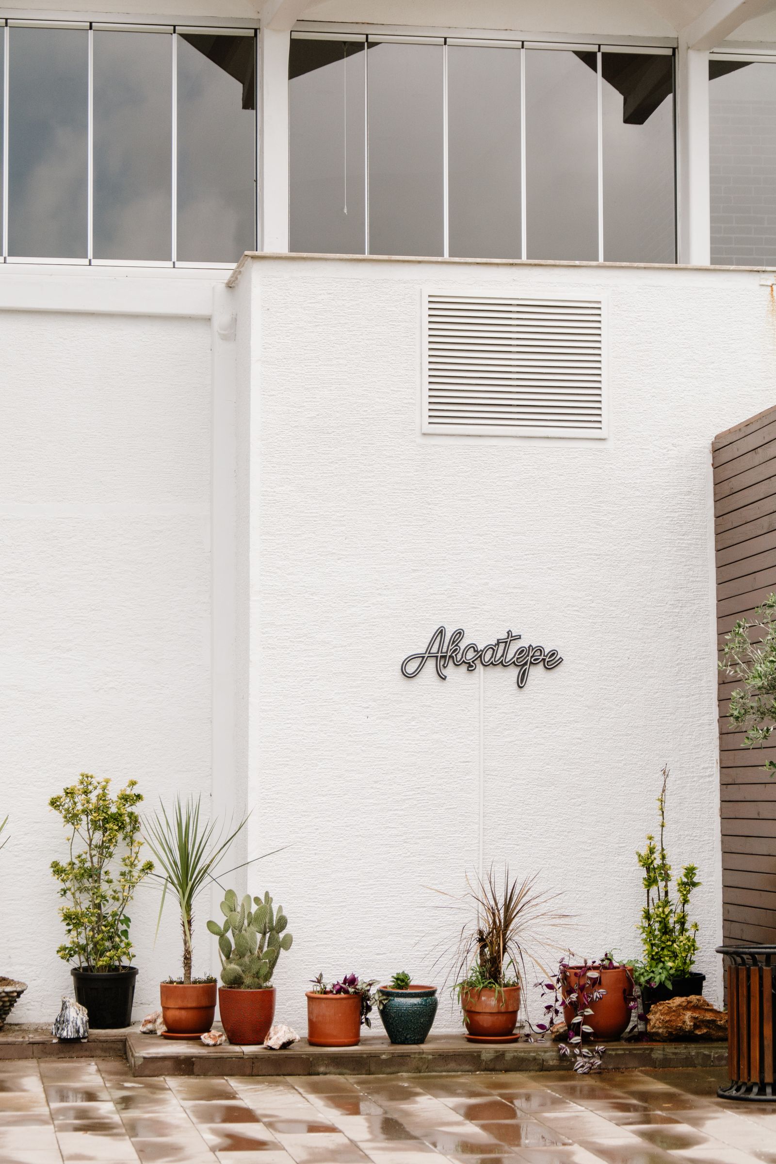 Patio contemporáneo con fachada blanca y plantas en macetas